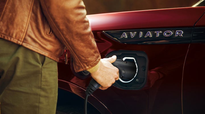 A hand is shown plugging in the charger into the charging port of a 2021 Lincoln Aviator | Bayway Lincoln in Houston TX