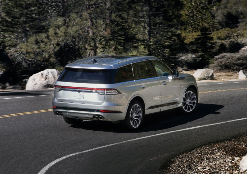A 2023 Lincoln Aviator® Grand Touring model is shown being driven on a tight turn of a mountain road | Bayway Lincoln in Houston TX