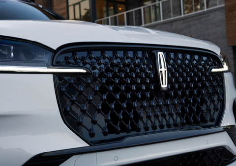 The black grille of a white 2025 Lincoln Aviator® SUV is shown with its fog lights on. | Bayway Lincoln in Houston TX