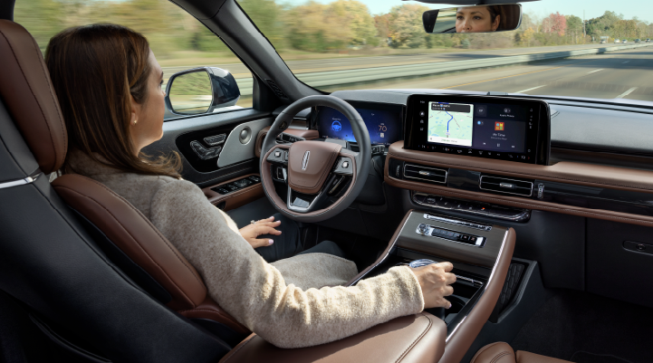 A woman is seen sitting in the driver’s seat of her 2025 Lincoln Aviator® SUV with her hands off the steering wheel. | Bayway Lincoln in Houston TX