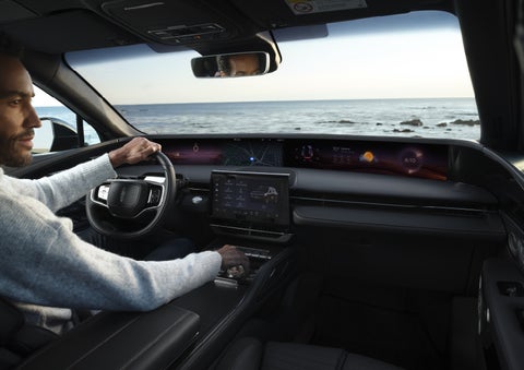 A driver of a parked 2026 Lincoln Nautilus® SUV takes a relaxing moment at a seaside overlook while inside his Nautilus. | Bayway Lincoln in Houston TX