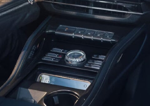 A smartphone is shown charging in the wireless charging pad. | Bayway Lincoln in Houston TX