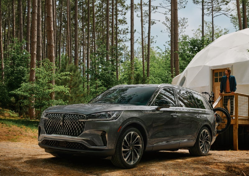 A 2027 Lincoln Aviator® is parked next to a high end glamping site. | Bayway Lincoln in Houston TX