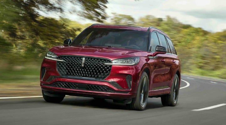 A 2027 Lincoln Aviator® SUV is being driven on a country road | Bayway Lincoln in Houston TX